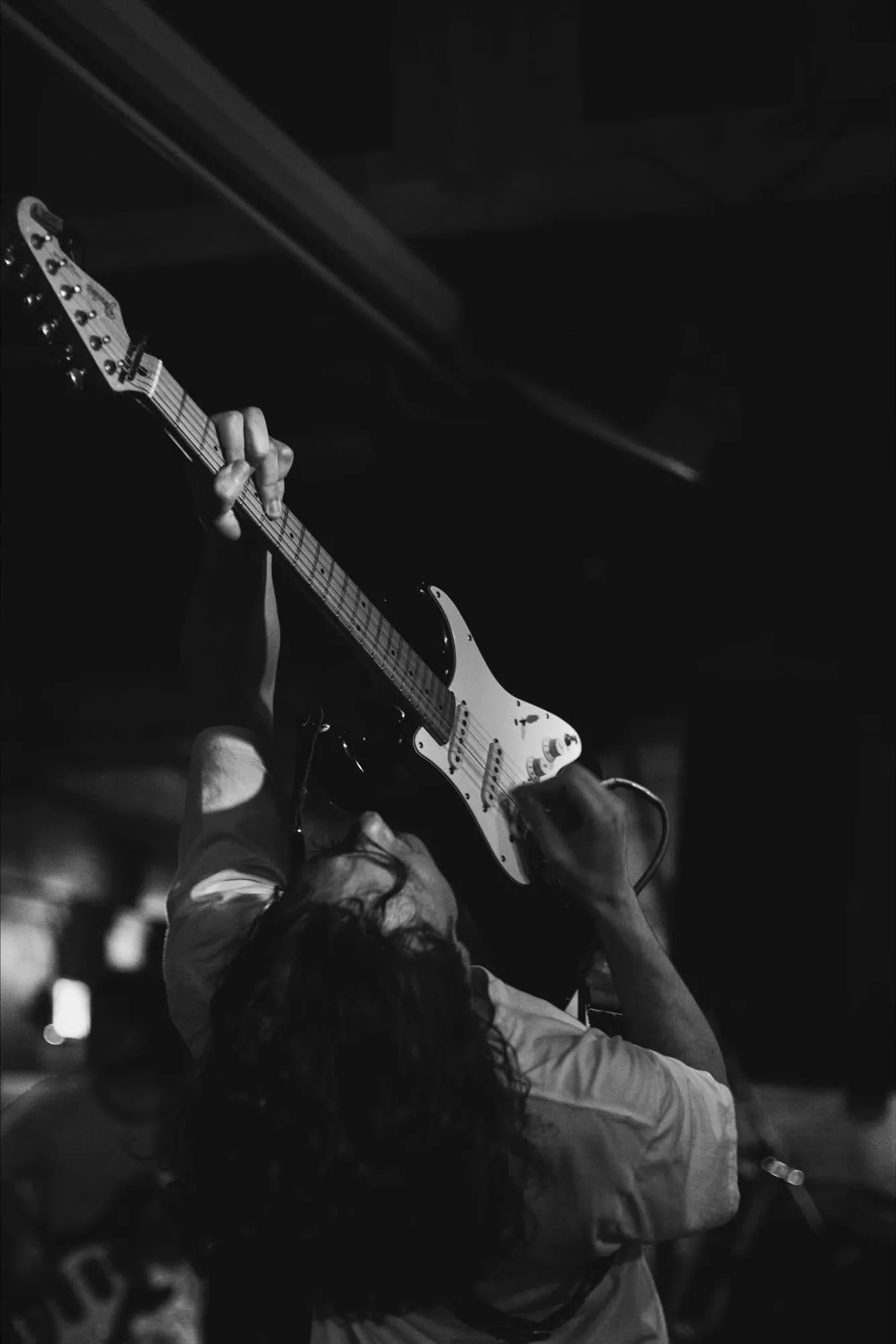 A guitarist with the neck raised over the stage
